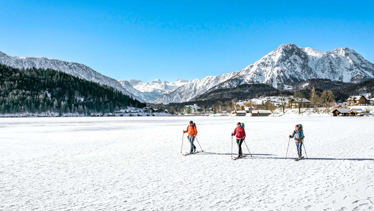 Bergsteiger spazieren am See entlang.