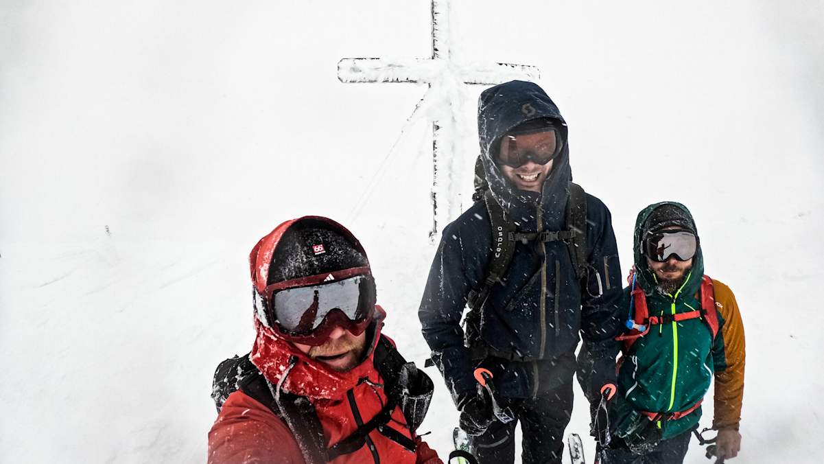 Skitourengeher beim Gipfelkreuz am Hohen Zinken
