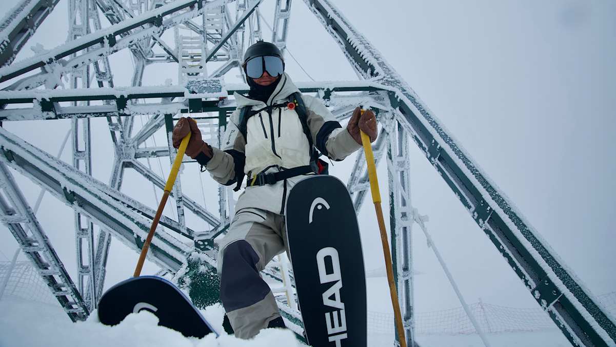 Freerider Tao Kreibich steht mit HEAD-Ski vor einer vereisten Metallkonstruktion in winterlicher Umgebung.