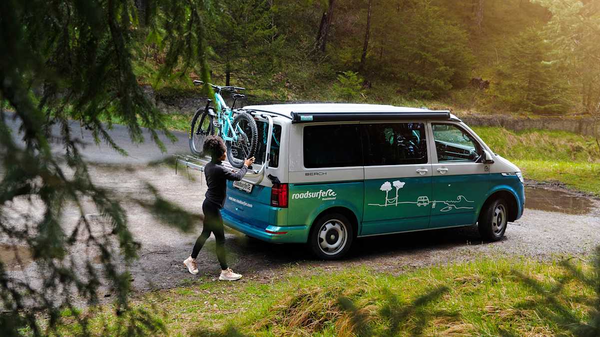 Mit dem Bike am Camper und dem Wald vor der Tür.