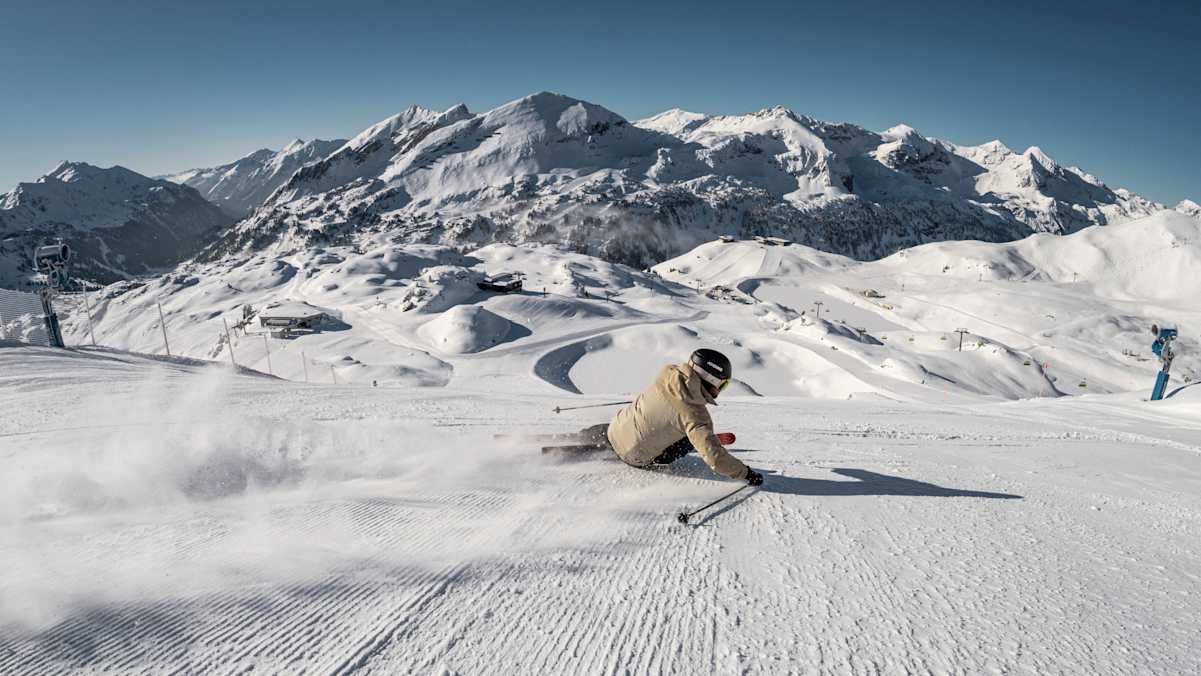 Ein Skifahrer carvt in hohem Tempo über die Pisten von Obertauern.