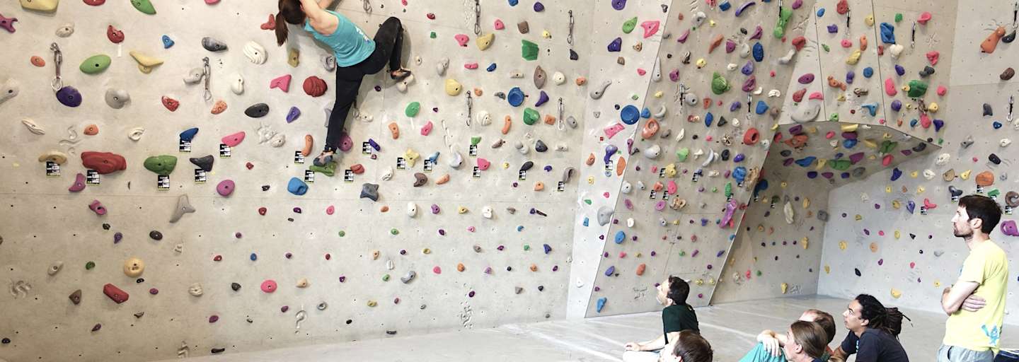 Eine Sportkletterlehrerin ist für Ausbildung und Training beim Bouldern und Vorstiegsklettern qualifiziert. 