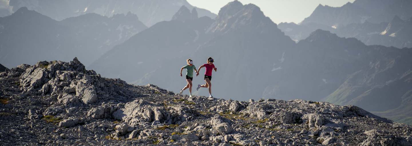 Zwei Frauen laufen über einen Berg