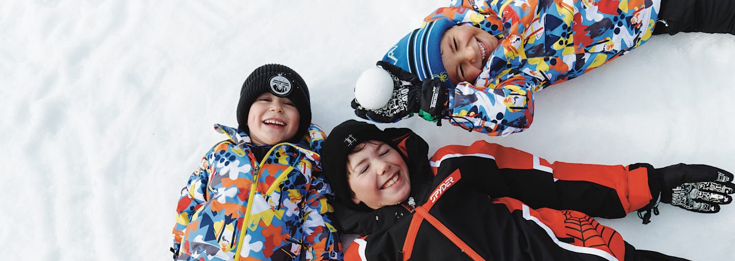 Drei Kinder liegen im Schnee in See.