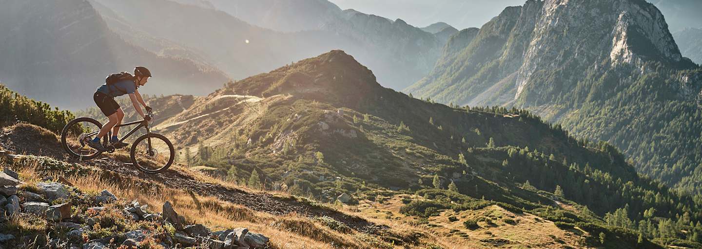 Abwärts in sanftem Licht: Mountainbiken mit Panoramablick.