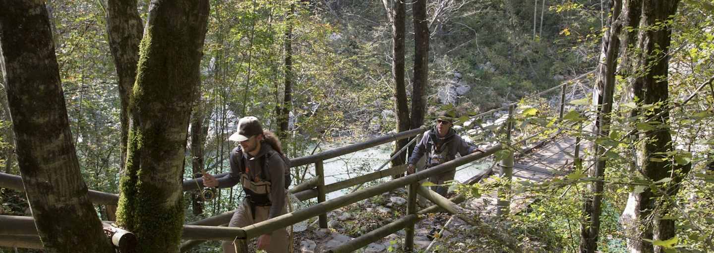 Fliegenfischer wandern durch den Bach