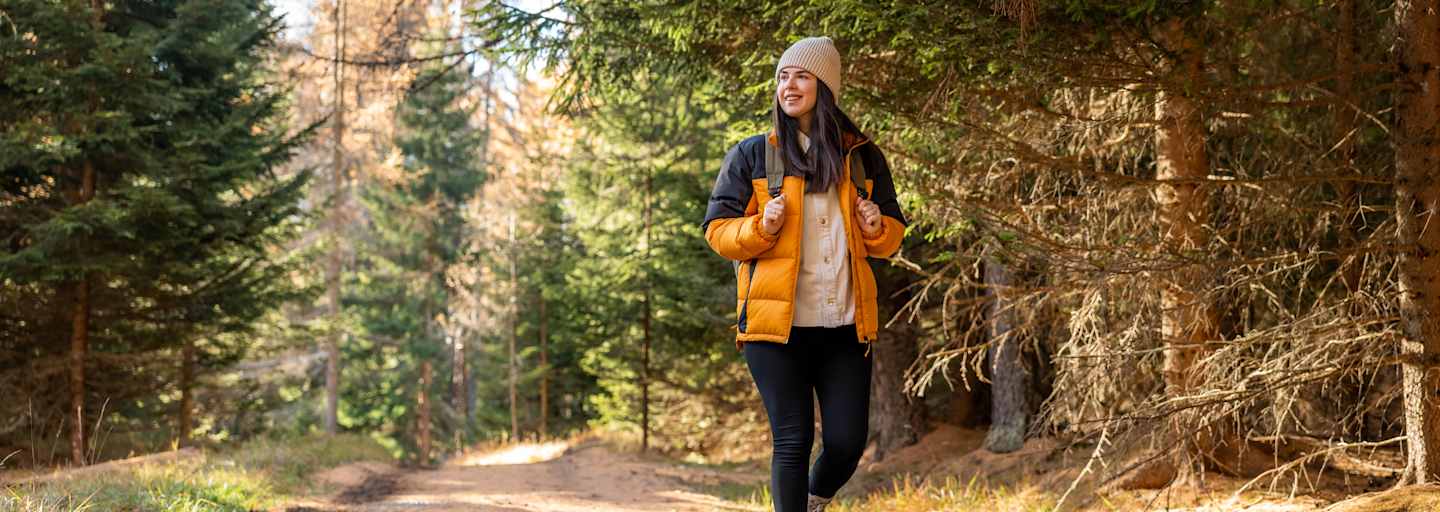 Frau wandert im wald im herbst