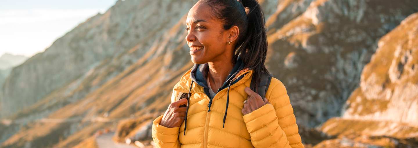 frau in den bergen beim wandern genießt den ausblick im herbst