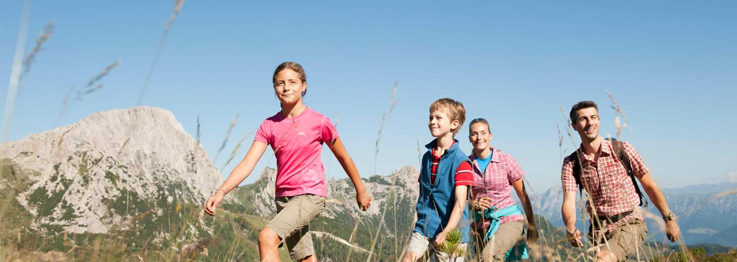 Eine Familie wandert auf einer Alm.