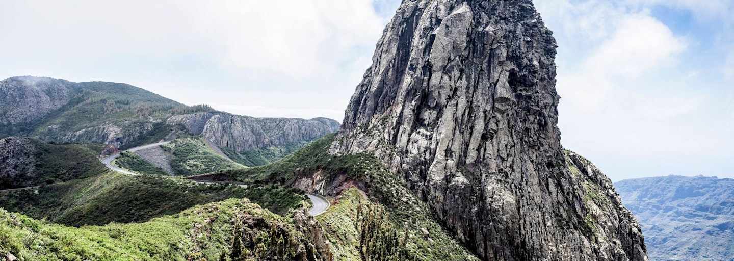 Ein Felsturm eingebettet in satten Grün