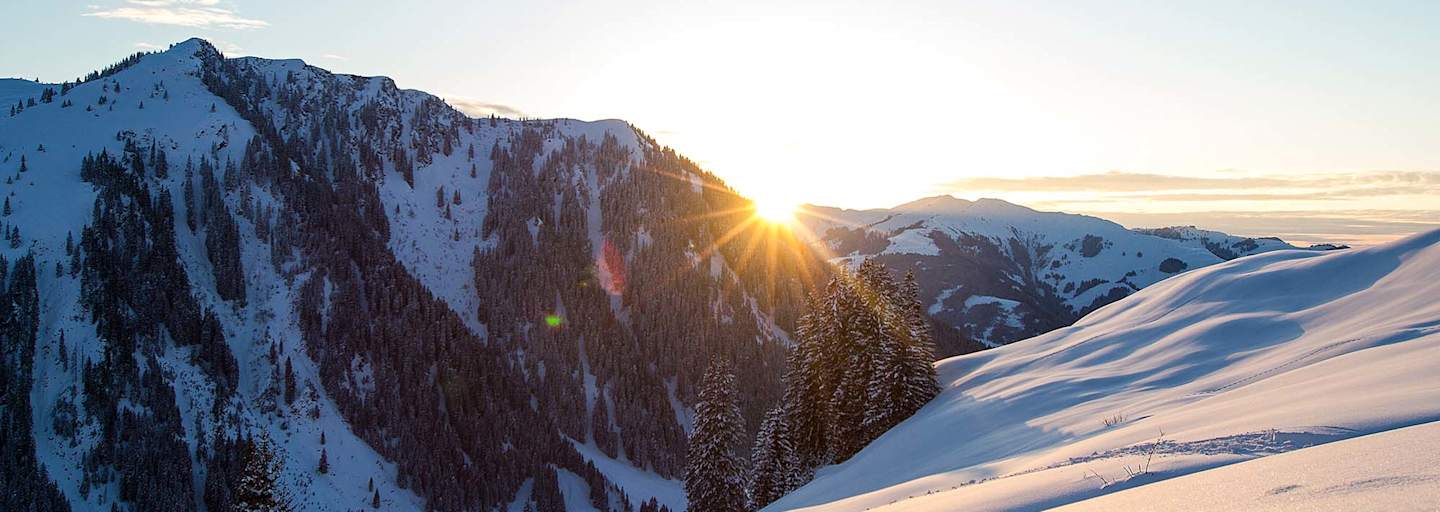 Die Abendsonne verschwindet hinter den schneebedeckten Gipfeln.