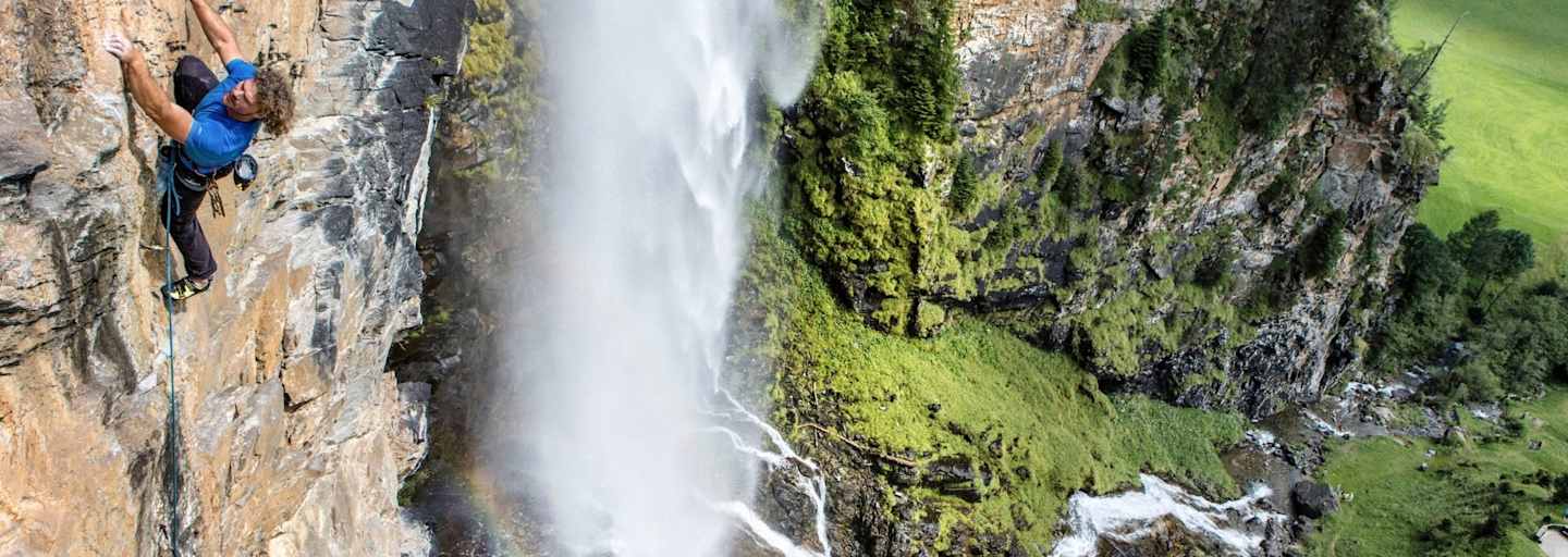 Kletterer klettert gesichert eine Bergwand hoch