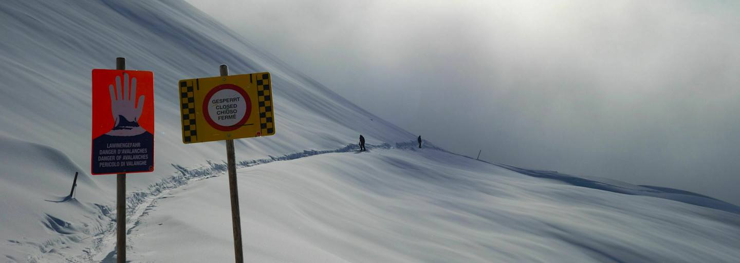 Schilder warnen vor Lawinengefahr im freien Gelände