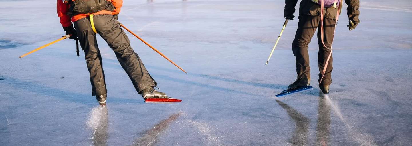 Zwei Nordic Skater mit Rucksäcken auf einem gefrorenen See nahe Uppsala 