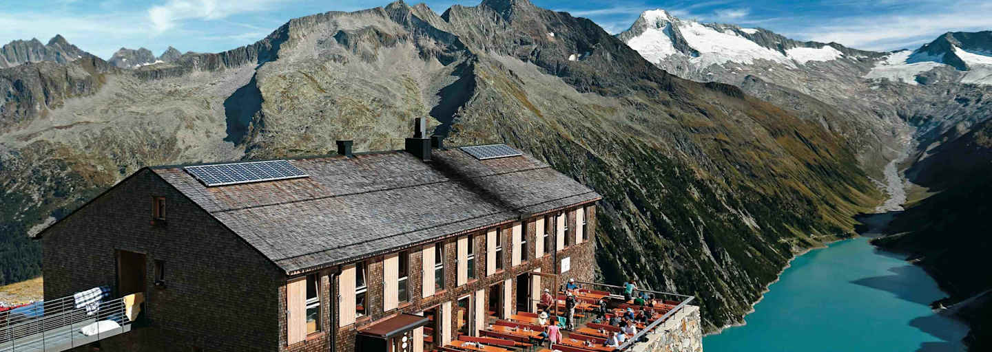 Die Olpererhütte besitzt einen Logenplatz über dem Schlegeis-Stausee. Dahinter Greinerkamm und der vergletscherte Möseler.