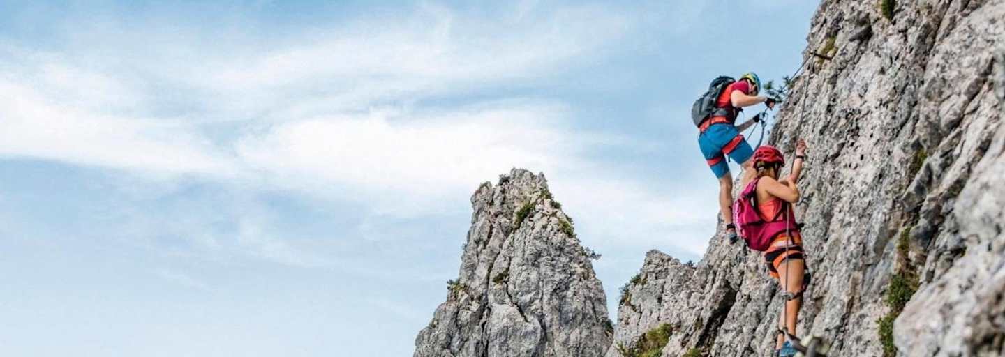 Kletterer am Pidinger Klettersteig und im Hintergrund das Alpenvorland
