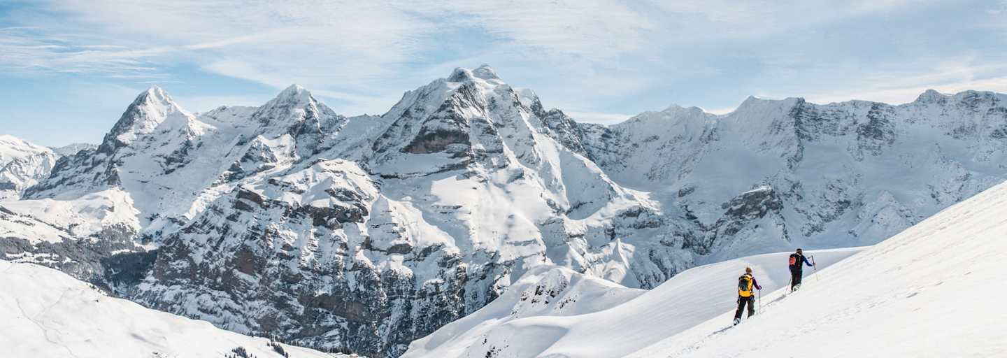 Zwei Schneeschuhwanderer vor atemberaubendem Bergpanorama.