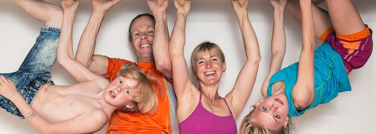 Eine Familie hängt mit den Händen auf einem Eisenträger in der Luft