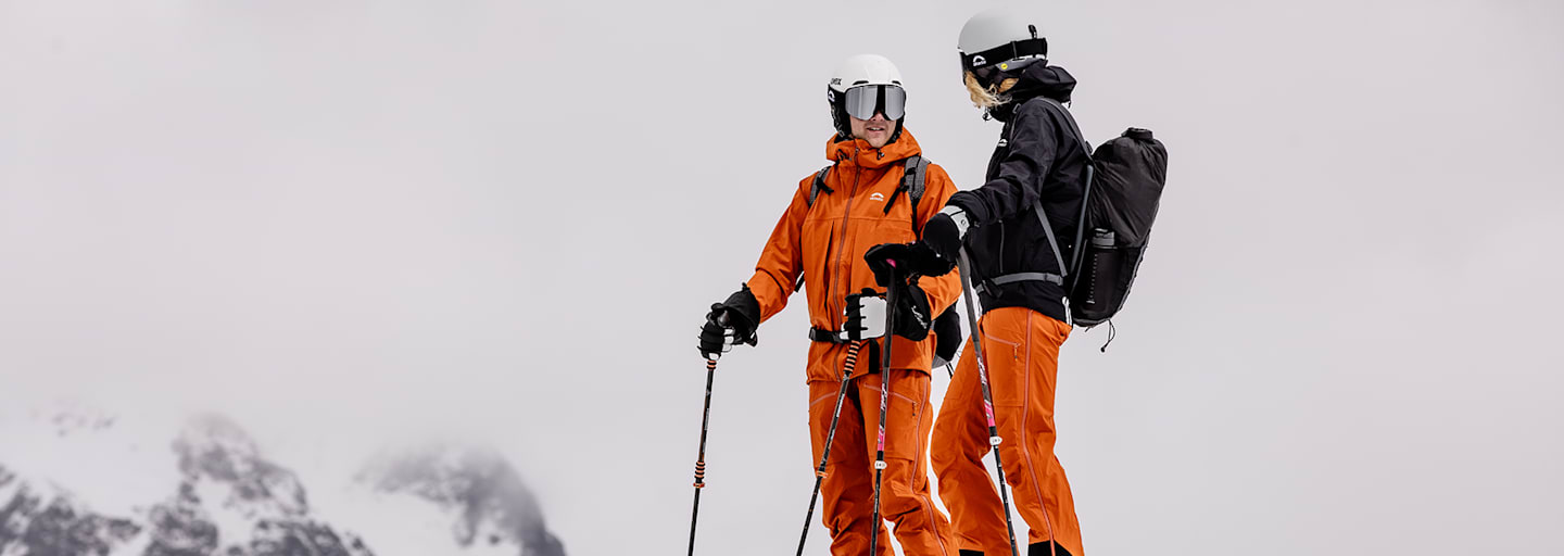 Zwei Personen auf dem Berg mit Ski und Ausrüstung von Skinfit.
