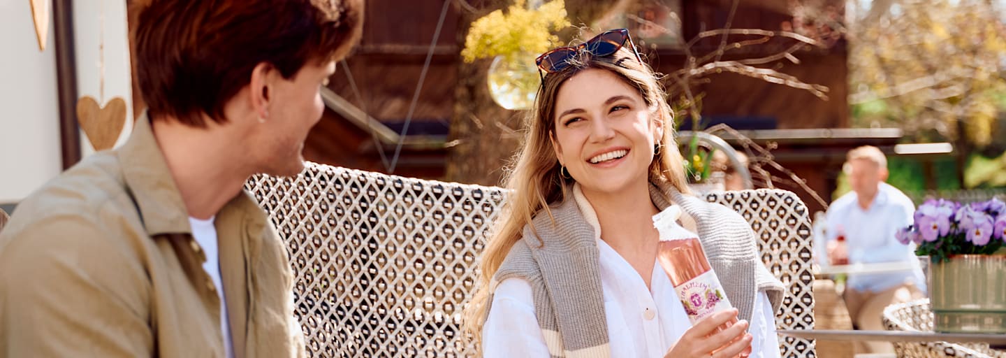 Eine Frau hält eine Thalheim Flasche mit Geschmack in der Hand und lächelt.