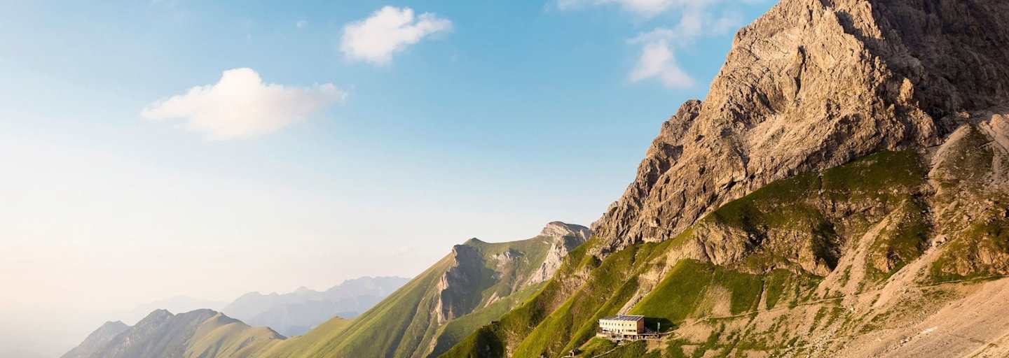 Das Waltenbergerhaus ist eingebettet in eine alpine Graslandschaft