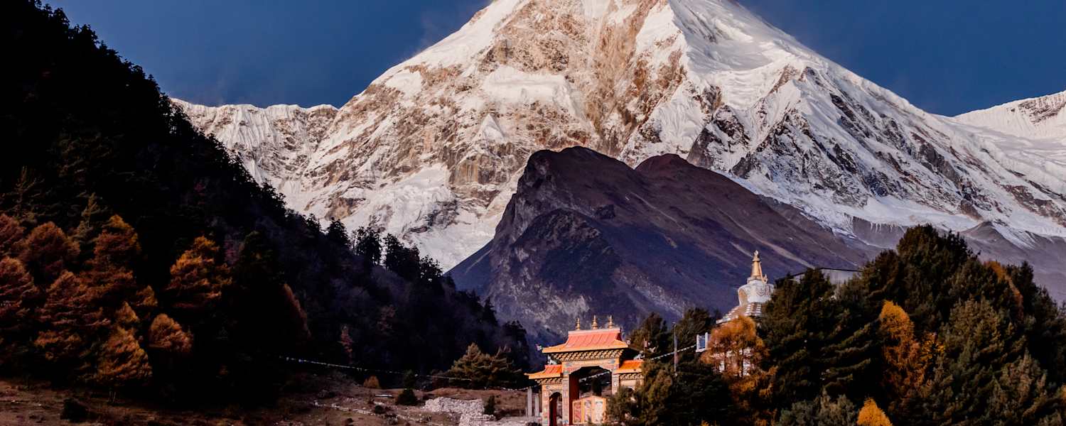 Ein Kloster und dahinter der mächtige Manaslu im Licht des Morgens