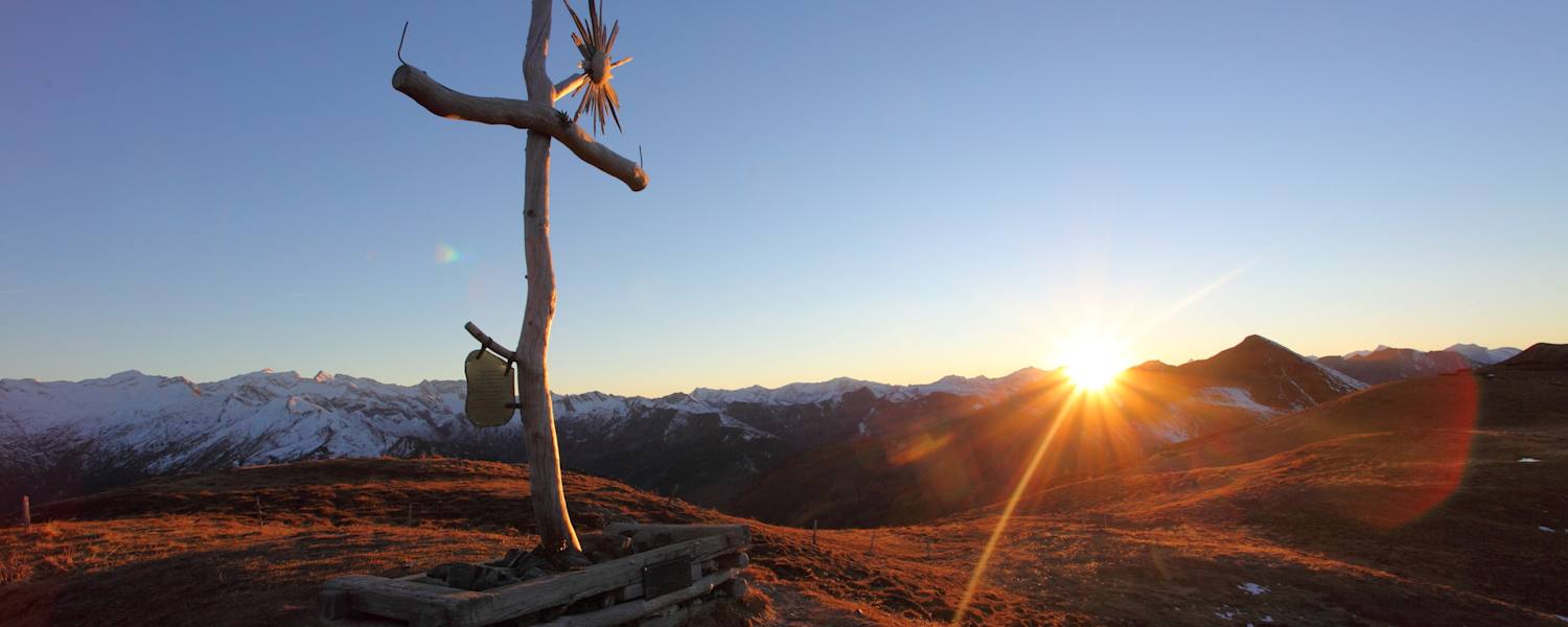 Gipfelkreuz auf der Filzmooshöhe bei Sonnenuntergang