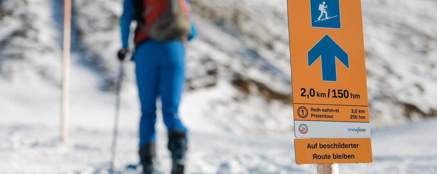 Das Pistentourenleitsystem des Landes Tirol mit orangen Hinweisschildern zeigt den sicheren Weg nach oben.