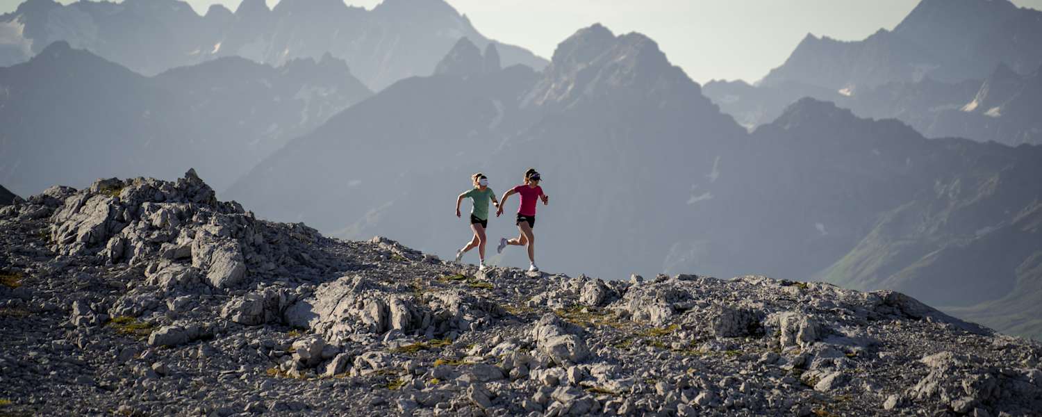 Zwei Frauen laufen über einen Berg