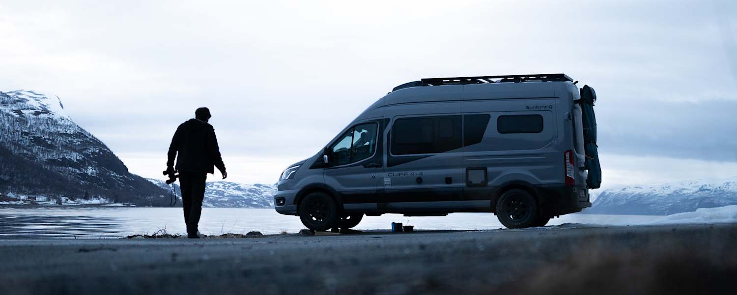 Ein Sunlight Camper steht vor einem See.