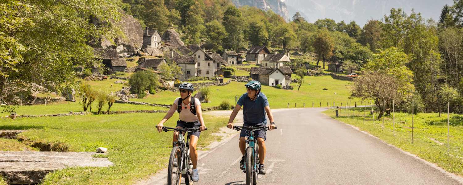 Zwei Fahrradfahrer fahren auf den gut ausgebauten Straßen im Kanton Tessin.
