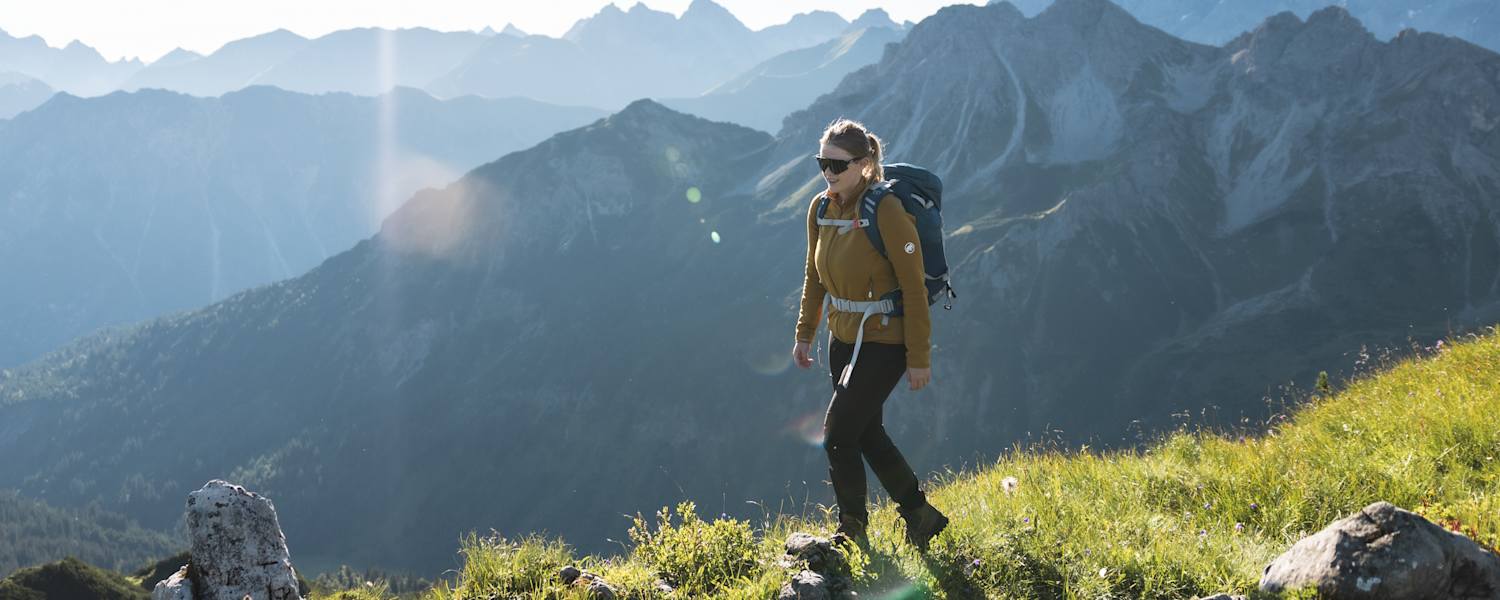 Eine Wanderin vor einer Bergkulisse.