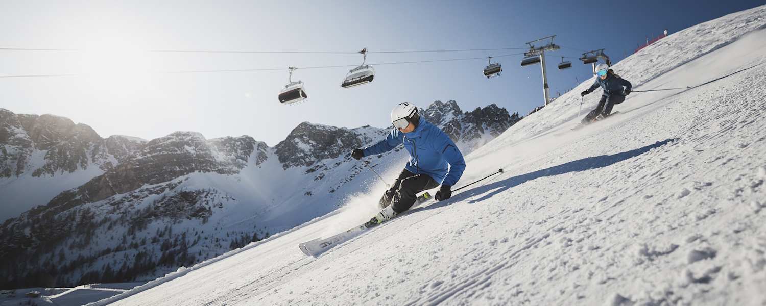 Zwei Skifahrer fahren die perfekt präperierten Pisten in Sterzing-Ratschings-Gossensass hinunter.