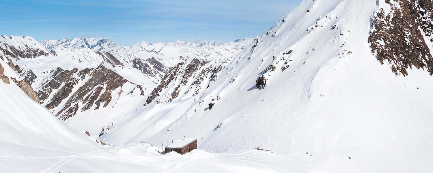 Die moderne Hütte schmiegt sich in die alpine Landschaft.