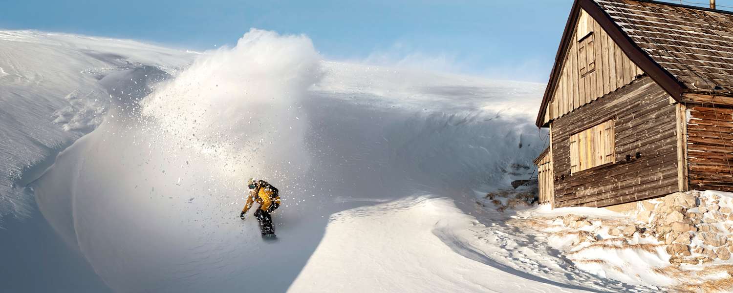 Ein Freerider fährt an einer Hütte vorbei