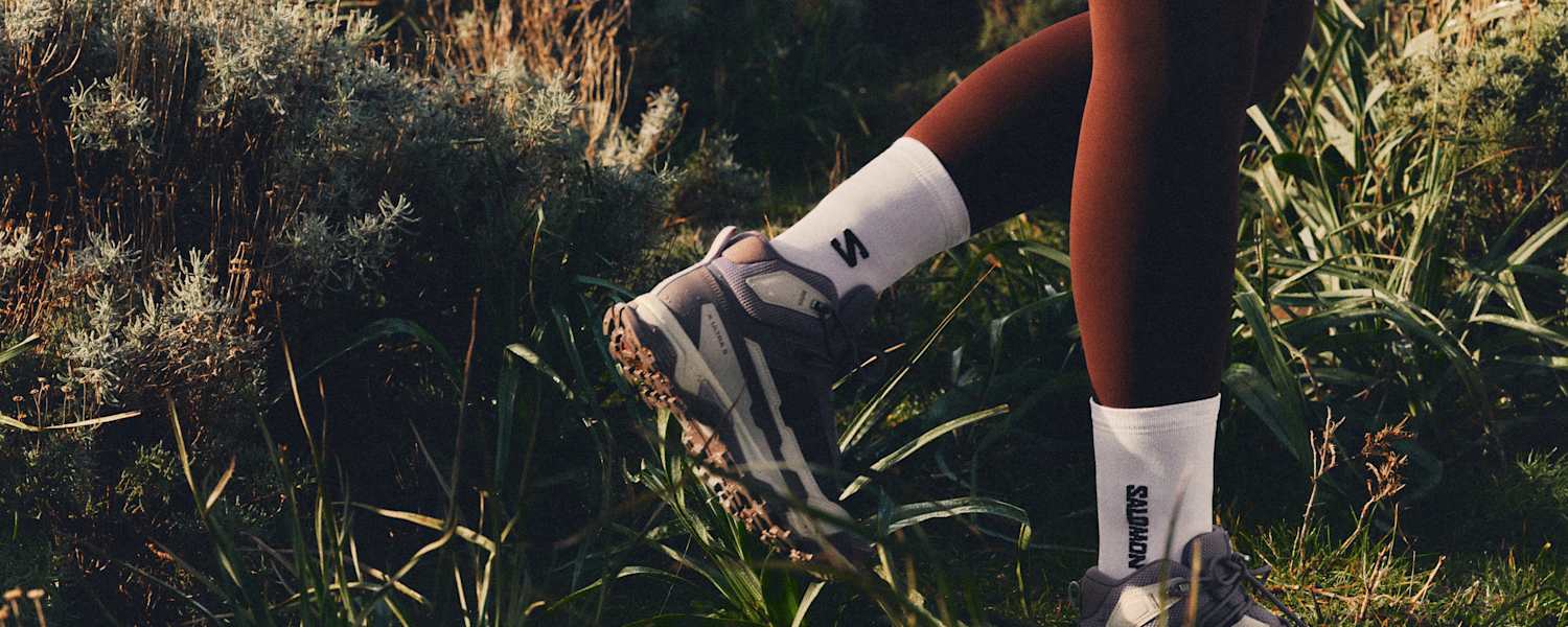 füße in salomon ausrüstung im gras beim wandern