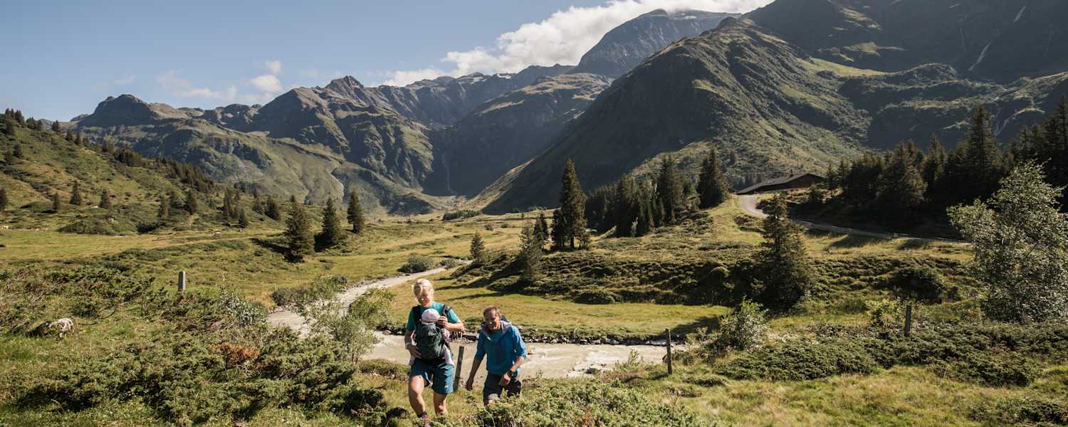 Zwei Wanderer mit Baby stapfen durch das Gasteinertal.