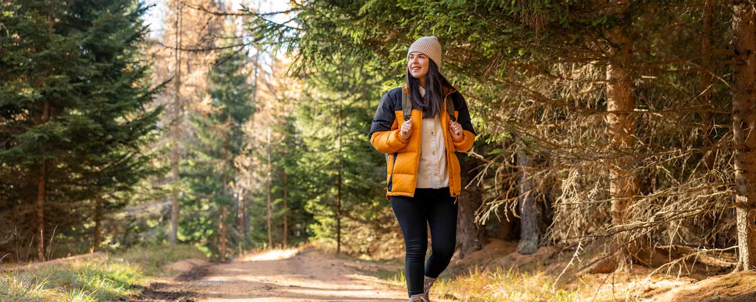 Frau wandert im wald im herbst