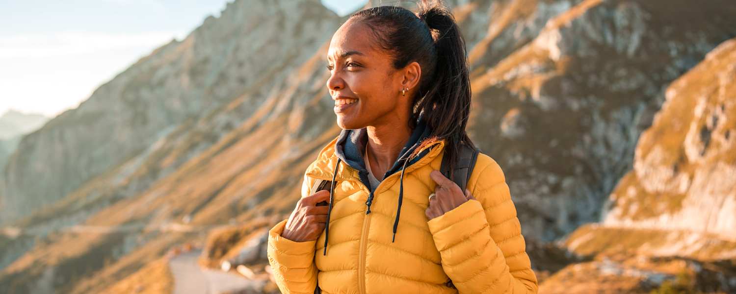 frau in den bergen beim wandern genießt den ausblick im herbst