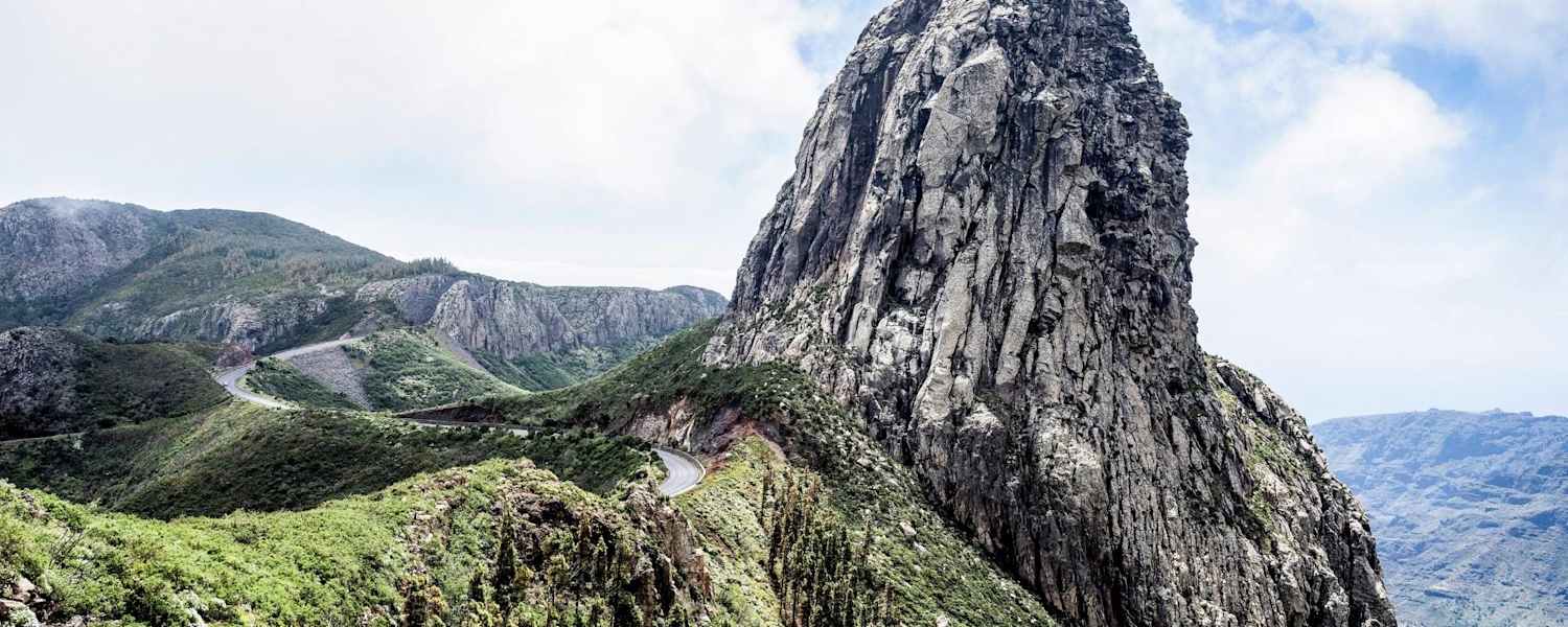 Ein Felsturm eingebettet in satten Grün