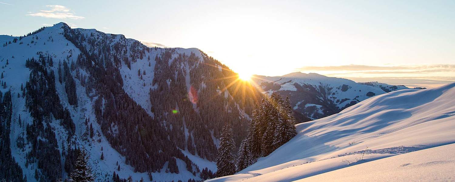 Die Abendsonne verschwindet hinter den schneebedeckten Gipfeln.