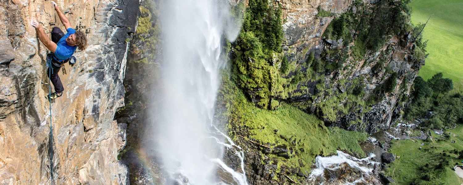 Kletterer klettert gesichert eine Bergwand hoch