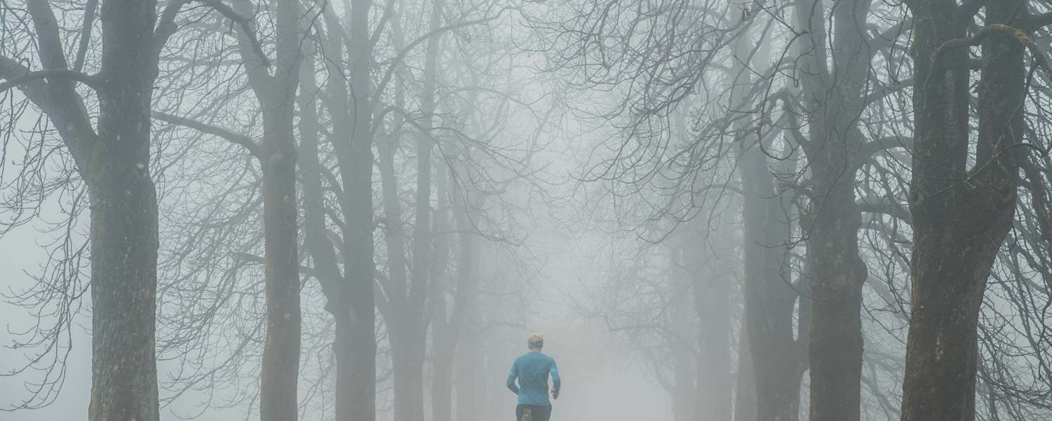 Läufer bei Nebel im Park
