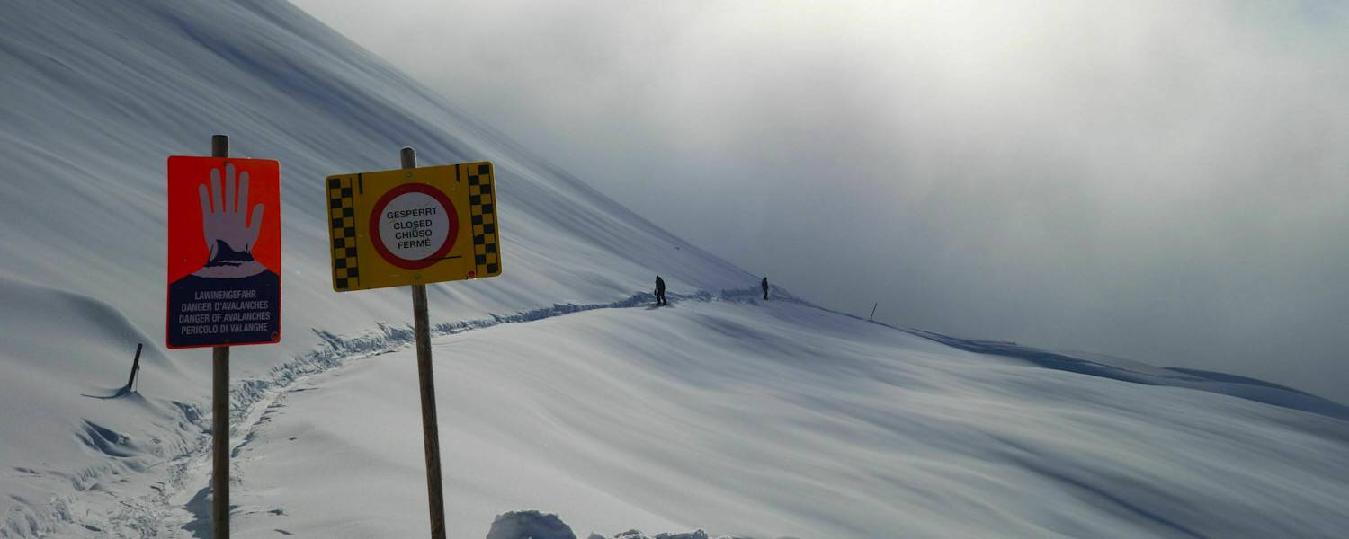 Schilder warnen vor Lawinengefahr im freien Gelände