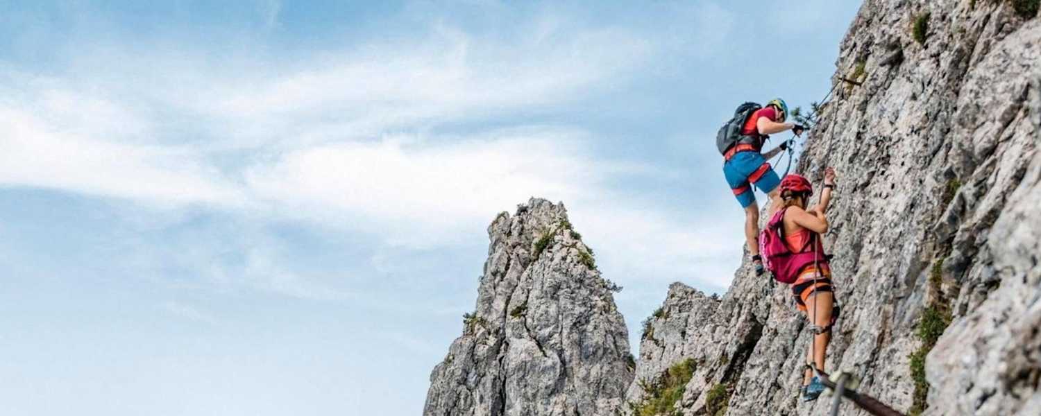 Kletterer am Pidinger Klettersteig und im Hintergrund das Alpenvorland