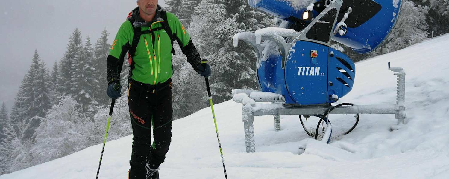 Skitourengeher im Skigebiet auf präparierter Piste