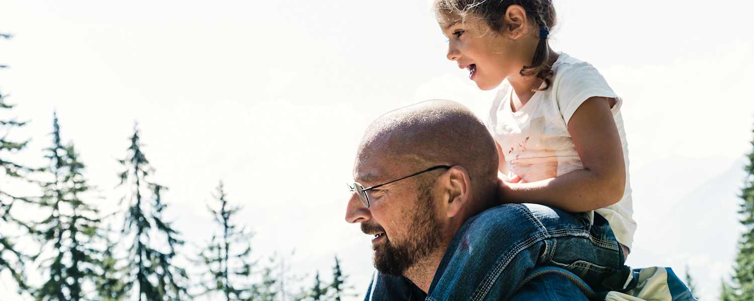 Das kleine Mädchen Lina sitzt auf den Schultern ihres Papas.