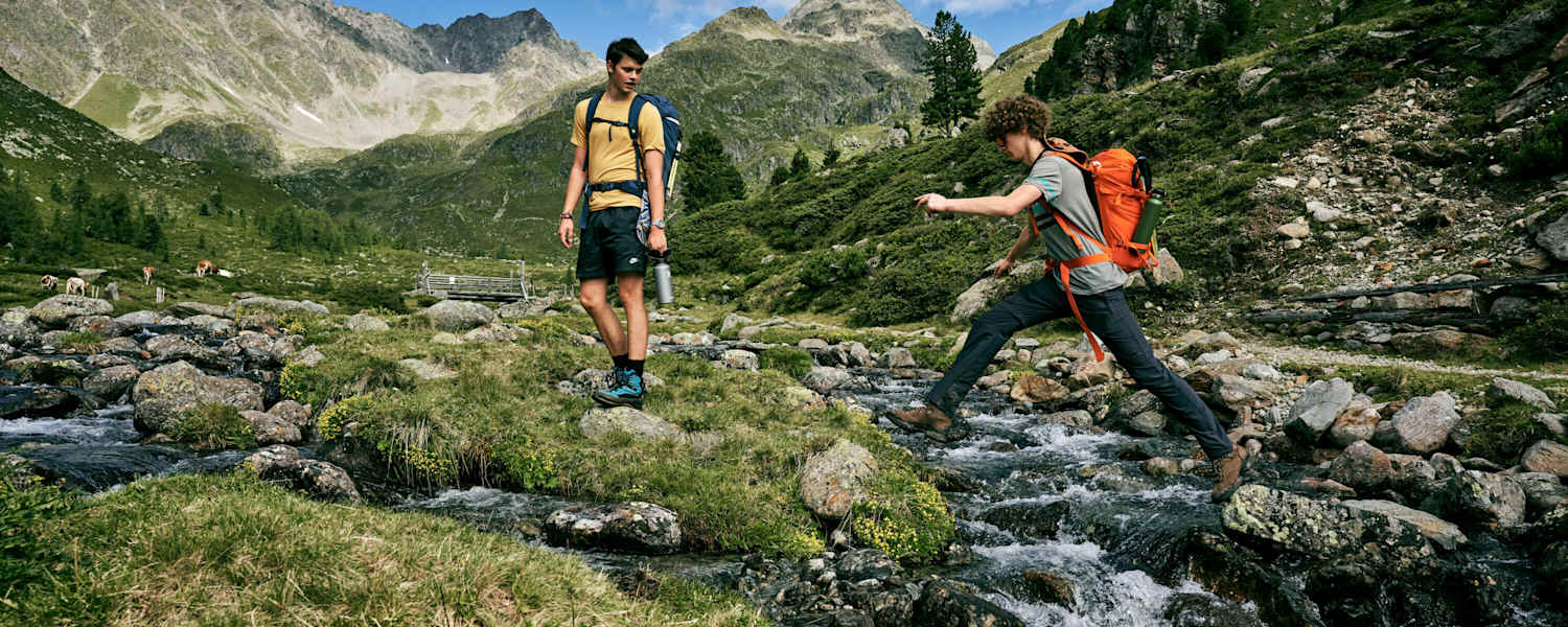 Person springt über Bergbach