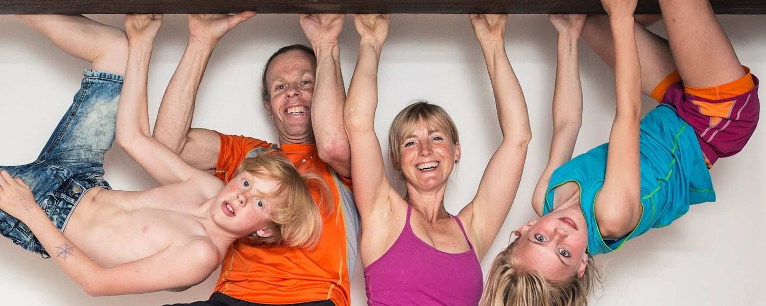 Eine Familie hängt mit den Händen auf einem Eisenträger in der Luft
