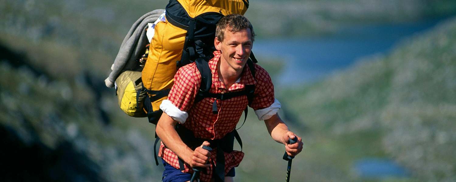 Trekking: Wanderer mit Teleskopstöcken im Gelände